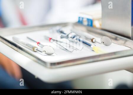 Outils ou instruments médicaux stériles pour un dentiste, miroirs, pincettes, et seringue pour l'anesthésie locale dans un cabinet dentaire Banque D'Images