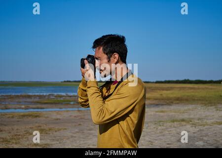 homme blanc prenant une photo avec l'ancien appareil photo dans le champ Banque D'Images