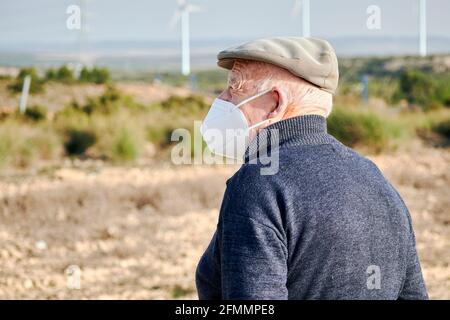 Homme âgé avec un masque facial regardant l'horizon Banque D'Images