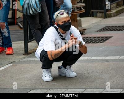 Medellin, Antioquia, Colombie - Mars 27 2021: La jeune femme latine regarde la performance du groupe de danse Banque D'Images