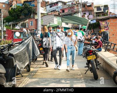 Medellin, Antioquia, Colombie - Mars 27 2021: Les touristes latins portant des masques de visage marchent dans la Tour de Comuna 13 Banque D'Images