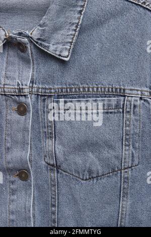 Gros plan sur le devant d'une veste en denim. Poche en Jean en gros plan. Arrière-plan de la veste en denim. Texture denim bleue pour l'arrière-plan. Banque D'Images