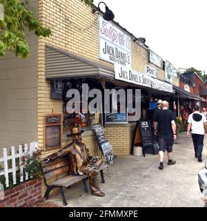 Lynchburg, TN, Etats-Unis - 23 septembre 2019 : boutique de souvenirs de Jack Daniel avec statue de Daniel sur banc dans le bloc commercial traditionnel près de la Banque D'Images