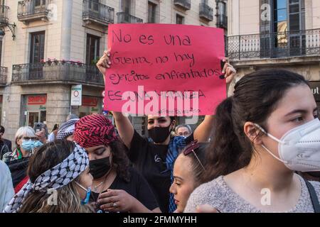 Barcelone, Espagne. 10 mai 2021. Un manifestant tient un écriteau disant que ce n'est pas une guerre, il n'y a pas d'armée de combat! C'est un massacre pendant la manifestation.la Communauté palestinienne de Catalogne a organisé une manifestation contre l'État d'Israël, devant la généralité de la Catalogne, Pour les incidents survenus ces derniers jours au cours desquels au moins 169 Palestiniens ont été blessés par la police israélienne près de la mosquée d'Al Aqsa à Jérusalem. Les Palestiniens protestent contre les projets d'expulsion de plus de 30 familles à Sheikh Jarrah pour faire place au peuple israélien. Crédit : SOPA Images Limited/Alamy Live News Banque D'Images