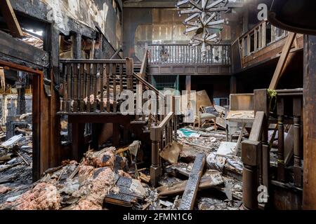 Ce qui reste du feu a endommagé le hall et le lustre un motel abandonné Banque D'Images