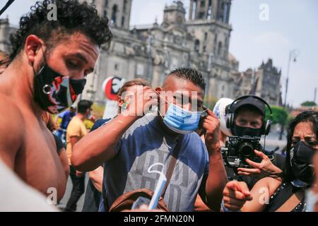 Mexique, Mexique. 10 mai 2021. Un homme de banlieue porte un masque qui lui est donné par les Luchadores mexicains. « la Brigade deux des trois chutes », appelée par le Mexican City Youth Institute, a fait un tour de Madero Street dans le centre historique en encourageant l'utilisation de masques de visage puisque la pandémie continue malgré le feu de circulation jaune épidémiologique. Crédit : SOPA Images Limited/Alamy Live News Banque D'Images