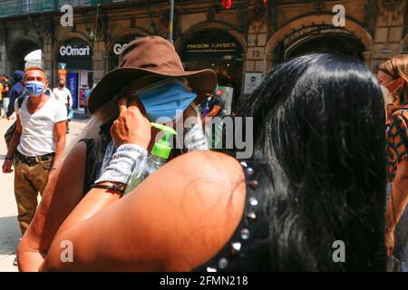 Mexique, Mexique. 10 mai 2021. Un Luchador mexicain aide un homme à porter un masque facial. « la Brigade deux des trois chutes », appelée par le Mexican City Youth Institute, a fait un tour de Madero Street dans le centre historique en encourageant l'utilisation de masques de visage puisque la pandémie continue malgré le feu de circulation jaune épidémiologique. (Photo de Guillermo Diaz/SOPA Images/Sipa USA) crédit: SIPA USA/Alay Live News Banque D'Images