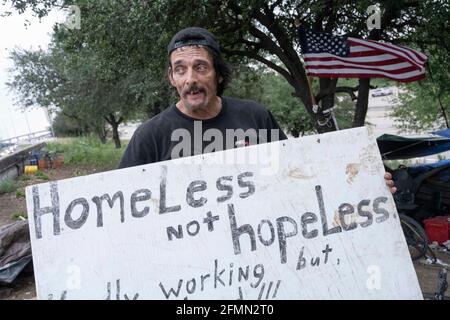 Le musicien et homme de main Douglas Crawford détient un panneau dans son camp à l'angle de Ben White Blvd. Et South Congress Avenue à Austin, TX, où il a vécu plus d'un an. Crawford, 60 ans, dit qu'il reste à lui-même et qu'il ne s'inquiète pas de la nouvelle répression d'Austin contre les sans-abri et de l'interdiction de camper à partir de mardi. ©Bob Daemmrich Banque D'Images