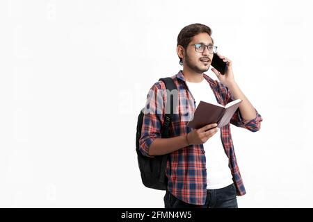 Étudiant indien parlant sur smartphone sur fond blanc. Banque D'Images