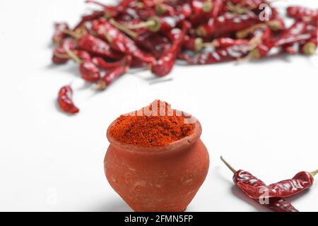 Poudre de piment rouge avec piments rouges séchés. Dans un bol en terre. Banque D'Images