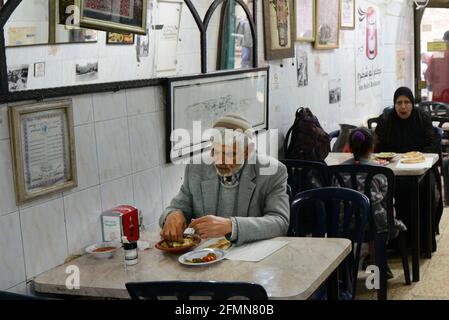Restaurant Abu Shukri, quartier musulman, vieille ville de Jérusalem. - UN homme palestinien mangeant de l'houmous dans l'un des restaurants de houmous les plus célèbres de Jérusalem. Banque D'Images