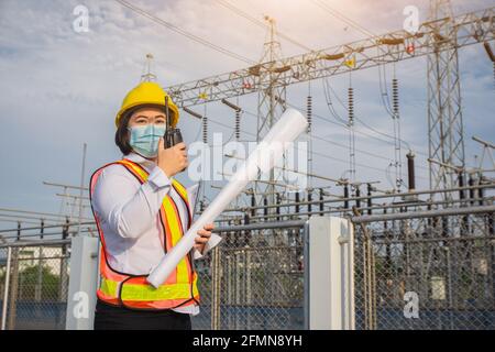 Femmes Ingénieur tenir photocalque , protection de masque de travail covid19 , les femmes utilisent la communication radio Banque D'Images