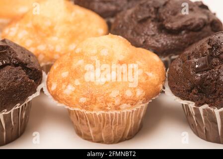 Muffins au chocolat avec morceaux de chocolat et muffins au citron décorés de cristaux de sucre sur fond blanc. Plaisir de thé. Banque D'Images