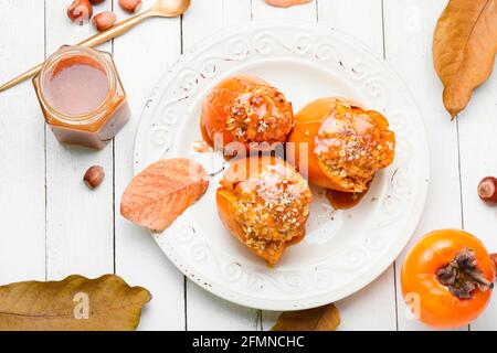 Persimmon farci de granola et de sauce caramel.Persimmon cuit savoureux. Banque D'Images