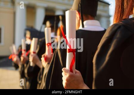 Diplômé.accent sélectif sur le diplôme diplôme certificat en main de l'étudiant debout dans la ligne Banque D'Images