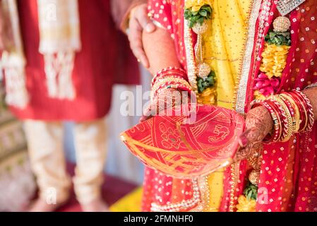 KOLKATA, INDE - 22 avril 2021: Le riz soufflé est versé dans le feu sacré un rituel dans un mariage indien. Banque D'Images