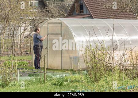 POLOGNE, Lomza - 01 mai 2021 : un agriculteur ouvre une serre avec des semis sur une ferme privée. Photo. Banque D'Images