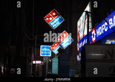 Février 2021, Kolkata, Inde, Neon signe des panneaux lumineux de Domino's pizza et HDFC Bank pendant la pandémie de verrouillage la nuit. Banque D'Images