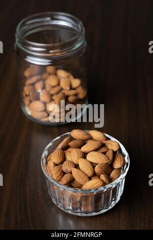 Pile d'amandes brutes pelées dans un bol sur un table en bois Banque D'Images