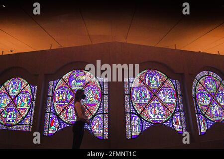 Un membre du personnel du British Museum de Londres regarde toute une fenêtre de vitraux vieille de 800 ans prêtant de la cathédrale de Canterbury au musée pour un nouveau « Thomas Becket: Le meurtre et la réalisation d'une exposition saint' qui se déroule du 20 mai au 22 août 2021, alors que le musée se prépare pour le public avant d'assouplir davantage les restrictions de confinement en Angleterre. Date de la photo: Mardi 11 mai 2021. Banque D'Images