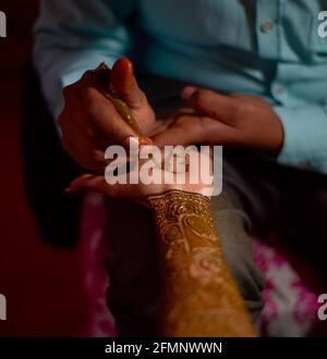 gros plan des mains de la superbe mariée indienne, appliquant hinna sur son mariage. Banque D'Images