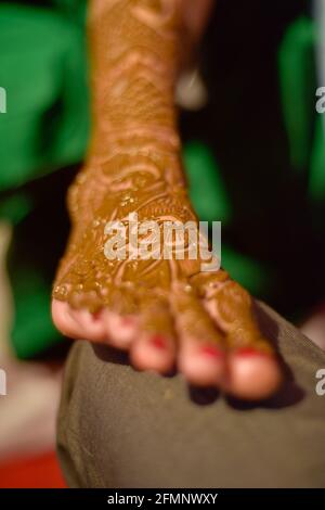 gros plan sur les jambes d'une superbe mariée indienne, appliquant hinna sur son mariage. Banque D'Images