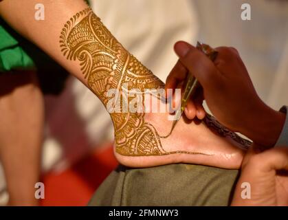 gros plan sur les jambes d'une superbe mariée indienne, appliquant hinna sur son mariage. Banque D'Images
