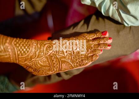 gros plan sur les jambes d'une superbe mariée indienne, appliquant hinna sur son mariage. Banque D'Images