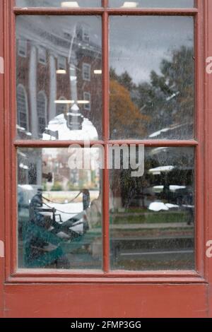 Une fenêtre à Weld Boat House à Cambridge, ma, avec des bateaux à l'intérieur et la vue au-delà, et réflexions d'un bâtiment et des arbres derrière le photographe Banque D'Images