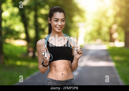 Joli Athletic Asian Girl s'entraîner avec saut de corde dans le parc, entraînement en plein air Banque D'Images