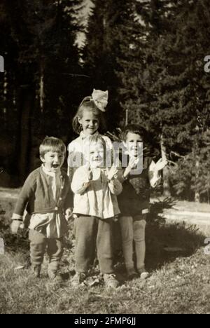 Groupe de jeunes enfants, garçons et filles souriants et heureux, âgés de 2 à 5 ans, jouant à l'extérieur vers 1968, Bulgarie Banque D'Images