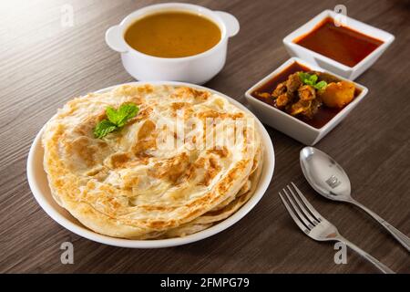 Roti Parata ou Roti Canai avec sauce au curry d'agneau - Petit déjeuner malaisien populaire Banque D'Images