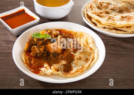 Roti Parata ou Roti Canai avec sauce au curry d'agneau - Petit déjeuner malaisien populaire Banque D'Images