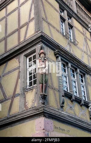 Bâtiment traditionnel avec la sculpture d'un homme en costume local, Colmar, Haut-Rhin (68), région du Grand est, France Banque D'Images