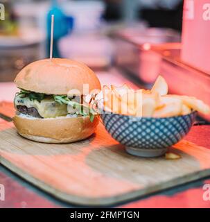 Cheeseburger gastronomique servi avec du pain maison et accompagné de français Frites Banque D'Images