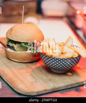 Cheeseburger gastronomique servi avec du pain maison et accompagné de français Frites Banque D'Images