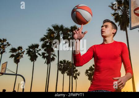 Joueur de basket-ball. Boule de panier tournant à la main. Équilibre du basket-ball sur le doigt. Sports et basket-ball. Banque D'Images