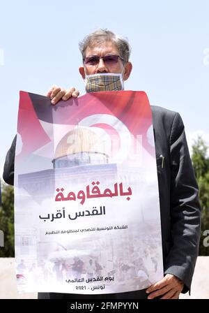 Tunis, Tunisie. 10 mai 2020. Un manifestant portant un masque facial tient un écriteau pendant une manifestation.des manifestants se sont rassemblés dans la capitale tunisienne pour protester contre l'entrée des forces de sécurité israéliennes dans Masjid al-Aqsa, qui est considéré comme un lieu sacré pour les musulmans. Crédit : Jdidi Wassim/SOPA Images/ZUMA Wire/Alay Live News Banque D'Images
