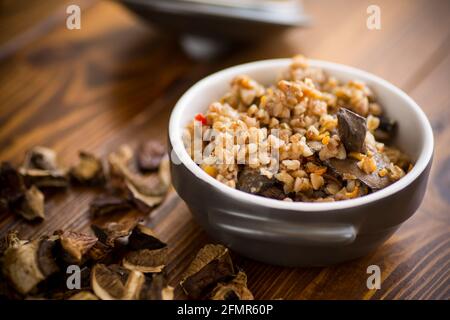 sarrasin bouilli avec champignons de forêt biologique séchés dans une céramique bol sur une table en bois Banque D'Images