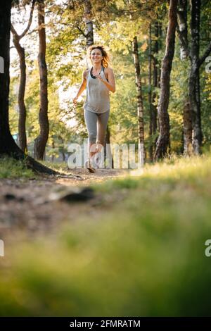 Une jeune fille gaie entre pour le sport dans le parc. Banque D'Images