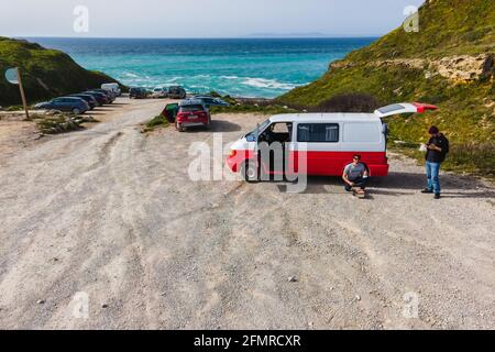 Setubal, Portugal - 27 mars 2021 : vue aérienne d'une automobile rouge et blanche garée sur la plage en nature, Setubal, Portugal. Banque D'Images