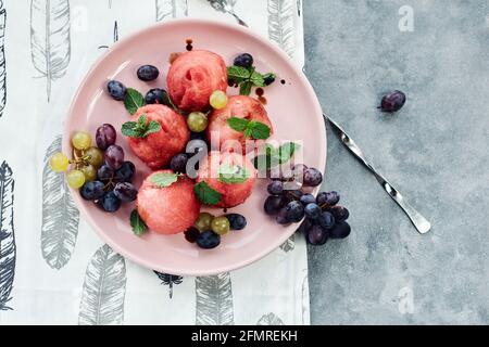 Boules de pastèque aux raisins et à la menthe, salade de fruits d'été. Banque D'Images