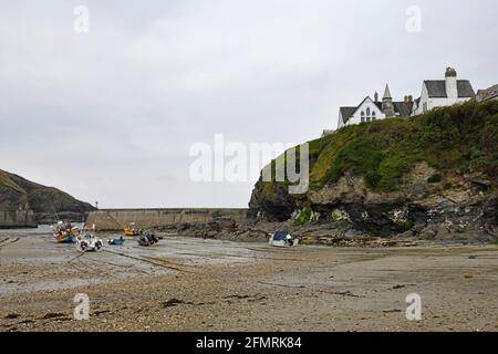 Port Issac avec bateaux de pêche et bateaux de plaisance Le sable et la vieille école sur la falaise Cornwall Angleterre Royaume-Uni Banque D'Images