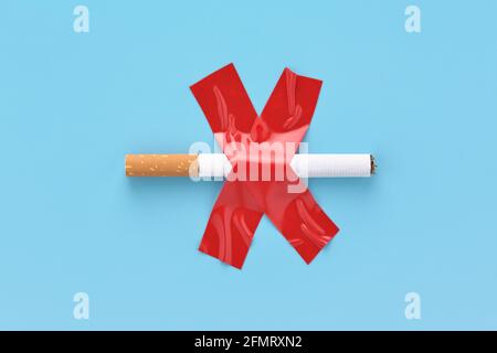 Cigarette barrée, collée avec du ruban adhésif rouge, concept interdit de fumer. Banque D'Images