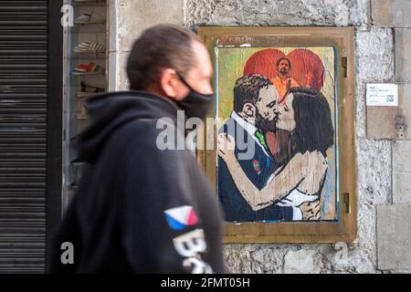 Un homme passe devant un nouveau graffiti de l'artiste TVBoy sur un mur à Barcelone.UN nouveau graffiti signé par l'artiste TVBoy, représentant le résultat des élections de la communauté de Madrid, qui s'est tenue le 4 mai 2021, où le président réélu, Isabel Díaz Ayuso, est vu embrasser Santiago Abascal, Chef du parti espagnol d'extrême droite Vox et membre du Congrès des députés en représentation de Madrid, devant Pablo Iglesias, ancien vice-premier ministre espagnol et candidat du parti de gauche Podemos, quittant la politique après les élections. Banque D'Images