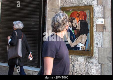 Un homme est vu regarder un nouveau graffiti de l'artiste TVBoy sur un mur à Barcelone.UN nouveau graffiti signé par l'artiste TVBoy, représentant le résultat des élections de la communauté de Madrid, qui ont eu lieu le 4 mai 2021, où la présidente réélue, Isabel Díaz Ayuso, Est vu embrasser Santiago Abascal, chef du parti espagnol d'extrême droite Vox et un membre du Congrès des députés en représentation de Madrid, devant Pablo Iglesias, ancien second vice-premier ministre de l'Espagne et qui était un candidat pour le parti de gauche, Podemos, quitter la politique après les élections. Banque D'Images