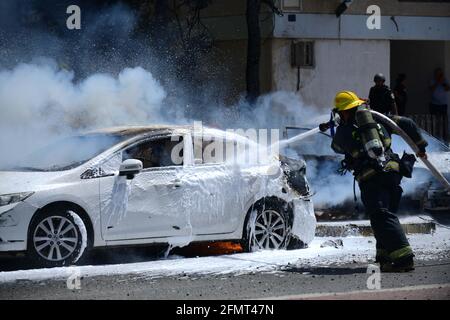 (210511) -- ASHKELON (ISRAËL), le 11 mai 2021 (Xinhua) -- un pompier israélien éteint un incendie après qu'une fusée de la bande de Gaza a atterri dans la ville d'Ashkelon, dans le sud d'Israël, le 11 mai 2021. Deux femmes israéliennes ont été tuées mardi après-midi à Ashkelon par des fusées depuis Gaza, a déclaré les autorités israéliennes, dans le cadre de l'une des pires poussées des dernières années. (Tomer Neuberg/JINI via Xinhua) Banque D'Images