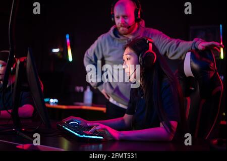 Sessions d'entraînement individuelles avec un entraîneur esports dans un club d'ordinateur, une fille asiatique joue dota. Banque D'Images