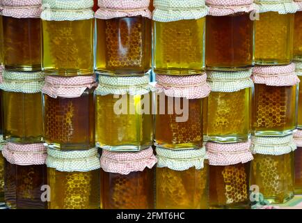 Pots de miel, disposés dans un coloré, avec les cellules. Banque D'Images