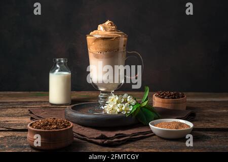 Café de la Dalgona coréenne avec de la mousse et de la glace sur fond marron. Vue latérale, horizontale. Une boisson revigorante. Banque D'Images